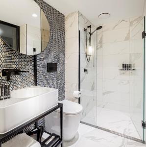 a bathroom with a shower, sink, and toilet at Brady Hotels Jones Lane in Melbourne