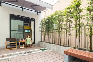een klein meisje aan een tafel op een patio bij Room Inn Shanghai 横浜中華街 Room1-ABC in Yokohama