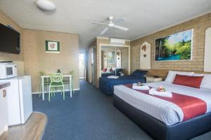 a hotel room with a bed and a living room at Iluka Motel in Iluka