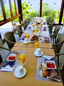 Hotel Casa Sayu في Tumbaco: طاولة طويلة مع أطباق من الطعام وكؤوس من عصير البرتقال