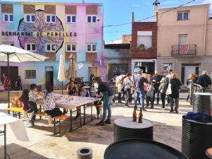 Casa Taller Penelles في Penellas: مجموعة من الناس يجلسون على الطاولات في الشارع