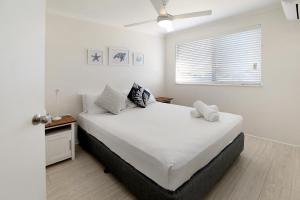 una camera da letto con un grande letto bianco e una finestra di MAINSAIL8- MOOLOOLABA BEACH a Mooloolaba