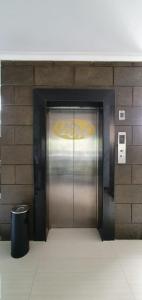 a metal elevator door in a building with a trash can at Bintang Mulia Hotel & Resto in Jember