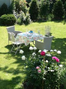 a table and chairs in a yard with flowers at Matrix Garden Apartments in Tallinn