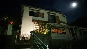 a white house at night with the moon behind it at The Sloope Nagasaki in Nagasaki