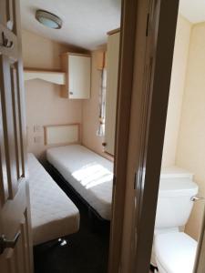 um pequeno quarto com 2 camas e um WC em Zacisze kurpiowskie u janusza em Zalas