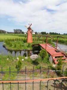 una granja con un molino de viento y un puente en Zacisze kurpiowskie u janusza en Zalas