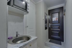 a bathroom with a sink and a black door at YourHouse микрорайон 1, дом 76 - экономичнее квартиры, уютнее гостиницы in Almaty