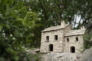 a stone house sitting on top of a rock at Apartmani Galić in Ploče