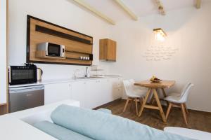 a living room with a kitchen and a table at Theros Luxury Villas in Karpathos