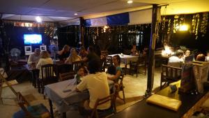 Ao Pong Resort في كو ماك: مجموعة من الناس يجلسون على الطاولات في المطعم