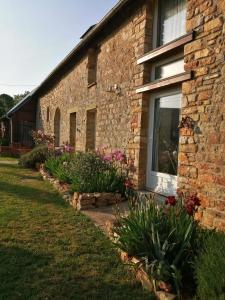 una casa de ladrillo con flores delante en Chambre d'hôtes La Ruzardière, en Combourtillé