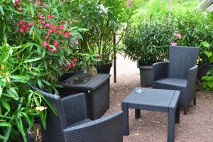 a patio with two chairs and a table and plants at Maison d'Hôtes La Chouanniere in Brion