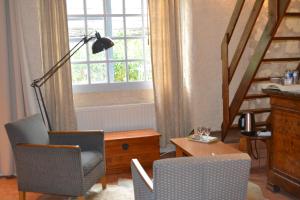 a living room with a chair and a desk and a window at Maison d'Hôtes La Chouanniere in Brion