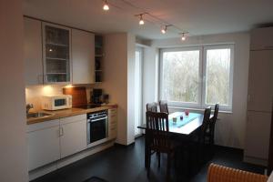 uma cozinha com uma mesa e uma cozinha com uma piscina em City Apartments Cologne - Apartment 1 em Colônia