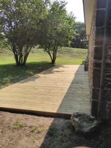 a wooden walkway next to a house with trees at Le Botcol in Plouguernével