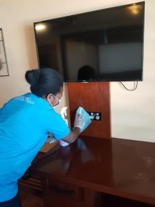 a woman is cleaning a table with a towel at Fatumaru Lodge in Port Vila