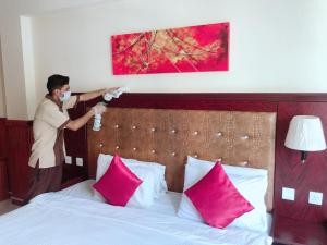 a woman standing over a bed with a mask on at Grand Nova Hotel in Dubai