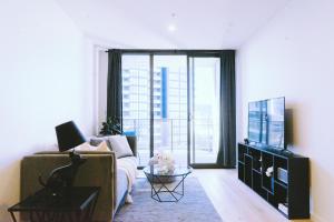 a living room with a couch and a tv at Capitol Executive Apartment on London Circuit in Canberra