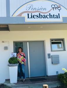 Schönau an der Brend的住宿－Pension Liesbachtal direkt am Waldrand Bayerische Rhön，站在医院前的妇女