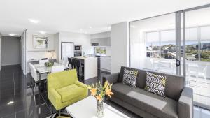 uma sala de estar e cozinha com um sofá e uma mesa em Oaks Brisbane Woolloongabba Suites em Brisbane