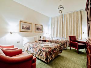 une chambre d'hôtel avec deux lits et deux chaises dans l'établissement Miodosytnia Aparthotel, à Cracovie