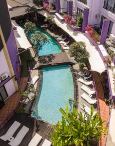 an overhead view of a swimming pool with lounge chairs at Kuta Central Park Hotel in Kuta