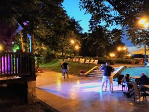 a group of people standing around a pool at night at Hotel Sarmata Zespół Dworski in Sandomierz