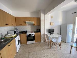 a kitchen with a table and a stove top oven at Orphanides Latchi Apartment in Polis Chrysochous