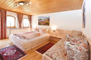 een slaapkamer met 2 bedden en een bank bij Ferienwohnung Fiel in Sankt Gallenkirch