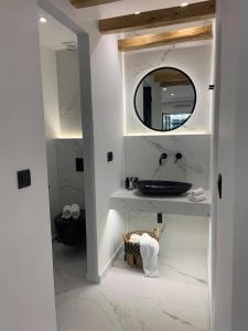 La salle de bains est pourvue d'un lavabo et d'un miroir. dans l'établissement Hotel Palatia, à Naxos Chora