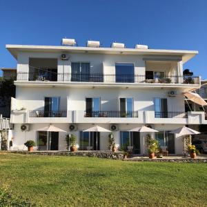 un edificio blanco con sombrillas blancas delante en Cloudberry, en Kalyves