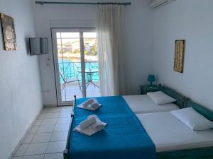 a bedroom with two beds and a balcony at Studios Apollonia in Skala Marion
