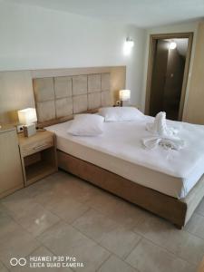 a bedroom with a large bed with two lamps on it at Studios Apollonia in Skala Marion