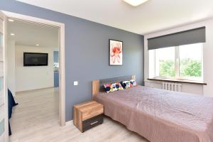 a bedroom with a large bed and a mirror at Butas Petera in Ventspils