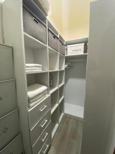 a walk in closet with white cabinets and towels at Om Tourist Residence in Trou d'Eau Douce