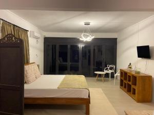 ein Schlafzimmer mit Bett und ein Wohnzimmer in der Unterkunft Om tourist Residence in Trou dʼ Eau Douce
