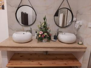 two sinks in a bathroom with two mirrors at Om Tourist Residence in Trou d'Eau Douce