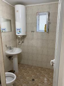 La salle de bains est pourvue de toilettes, d'un lavabo et d'une fenêtre. dans l'établissement Стаи за гости Маринови, à Provadiya