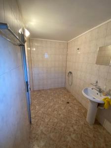 La salle de bains est pourvue d'un lavabo et d'une douche. dans l'établissement Стаи за гости Маринови, à Provadiya