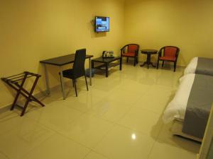 a room with chairs and a table and a bed at Twin Hotel in Kuala Lumpur