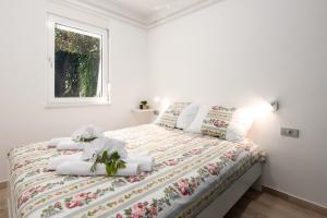 sypialnia z łóżkiem z białą pościelą i oknem w obiekcie Apartment Majda Opatija w mieście Opatija