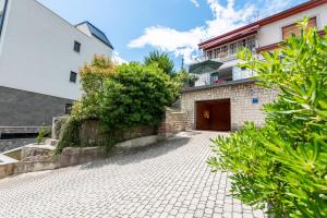 a house with a brick driveway in front of a building at Apartment Majda Opatija in Opatija
