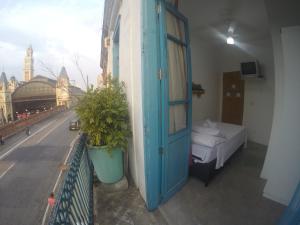 Cette chambre dispose d'une porte bleue et d'un lit sur un balcon. dans l'établissement Balcony Hostel Hotel, à São Paulo