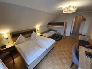 een slaapkamer met een groot wit bed en een bureau bij Hotel & Restaurant "Am Obstgarten" in Oberteuringen