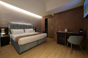 a bedroom with a bed and a desk and a chair at Hotel Bell'arrivo by Dori in Peschiera del Garda
