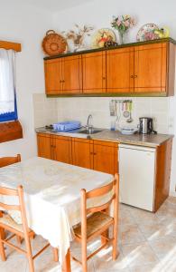 uma cozinha com uma mesa e um lavatório em Akrogiali Apartments em Lefkos