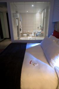 um quarto com uma cama grande e uma janela grande em Crowne Plaza Yas Island, an IHG Hotel em Abu Dhabi