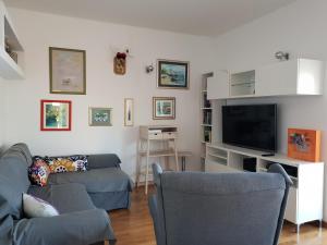 TV a/nebo společenská místnost v ubytování Cozy apartments with seafront terraces