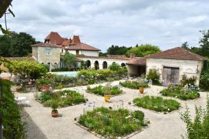 a garden in front of a house with flowers at Les Écuries de Saint Sever in Saint-Sever